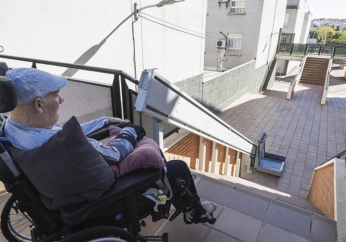 Antonio Rodríguez junto a la escalera mira la plataforma elevadora.