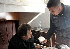 Un técnico explica a una mujer el uso de un detector de incendios en una imagen de archivo.