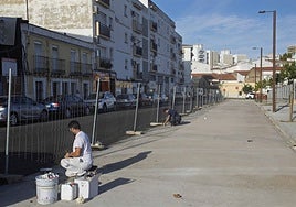 Dos operarios pintan las plazas de aparcamiento en Pontezuelas.