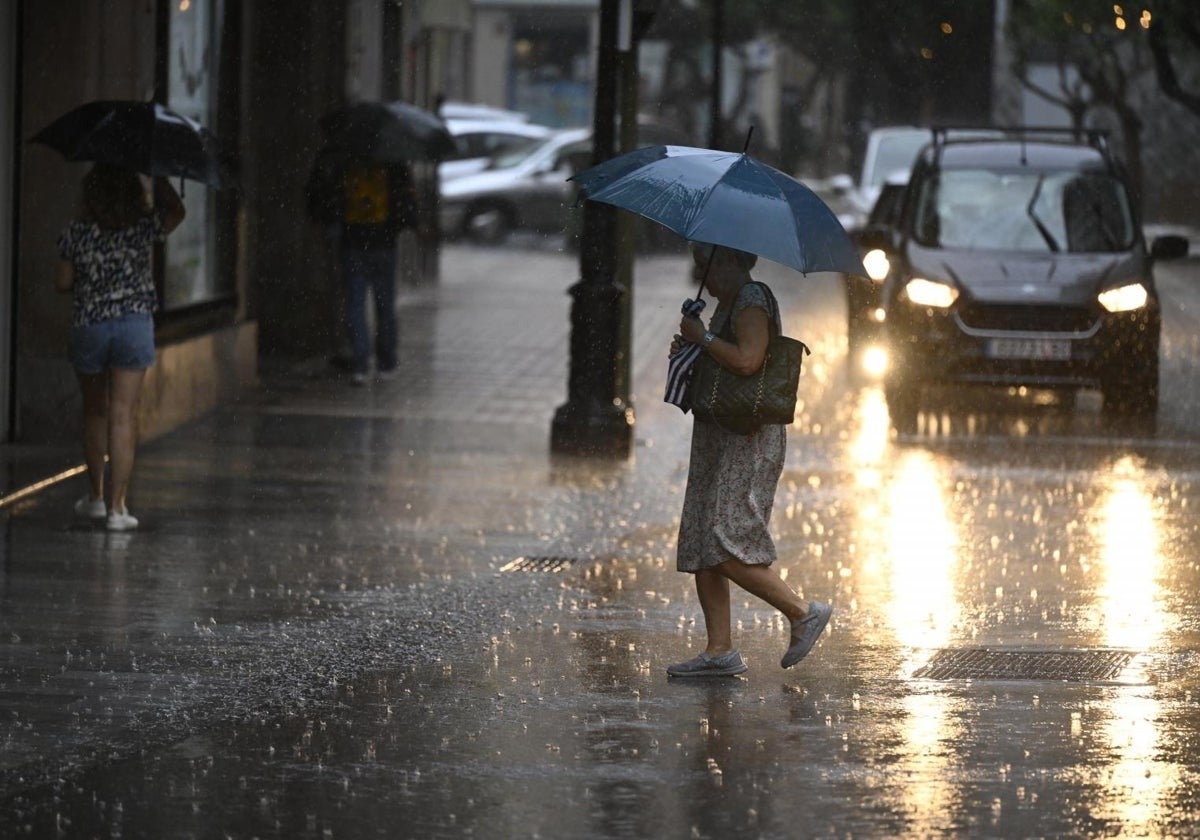 Una mujer se protege de la lluvia.