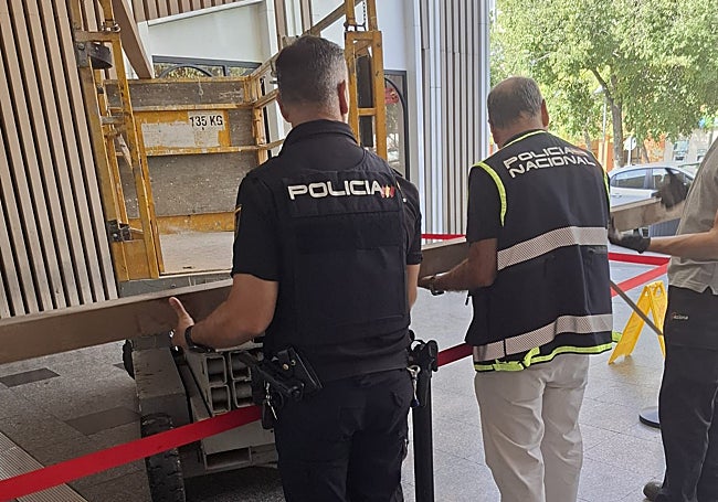 Varios policías sujetan el elemento decorativo desprendido del techo.