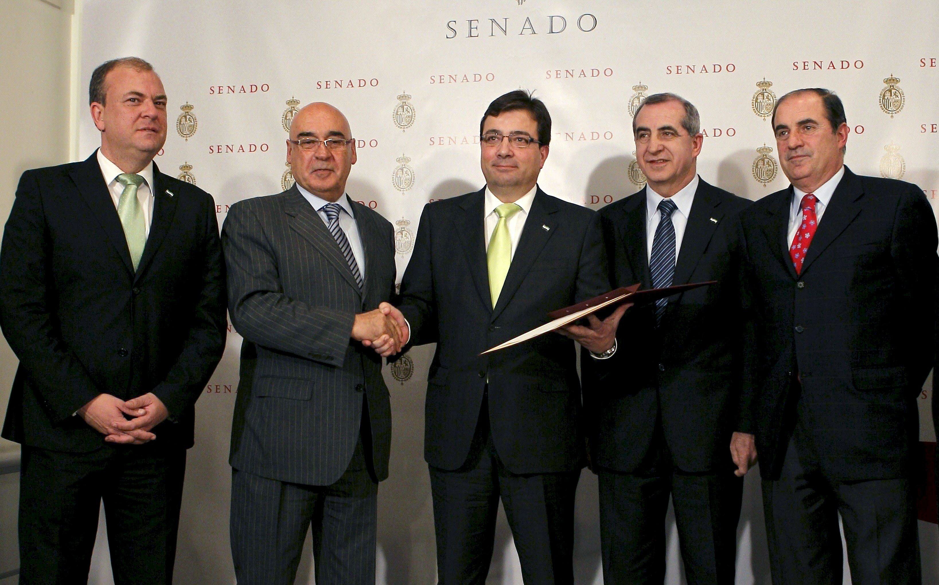El presidente del Senado, Javier Rojo (2i), saluda al presidente de Extremadura, Guillermo Fernández Vara (c), en presencia del presidente de la Asamblea de Extremadura, Juan Ramón Ferreira (2d), y otras autoridades, tras la aprobación de la reforma del Estatuto de Autonomía de Extremadura en el pleno celebrado en la Cámara Alta en 2011. 
