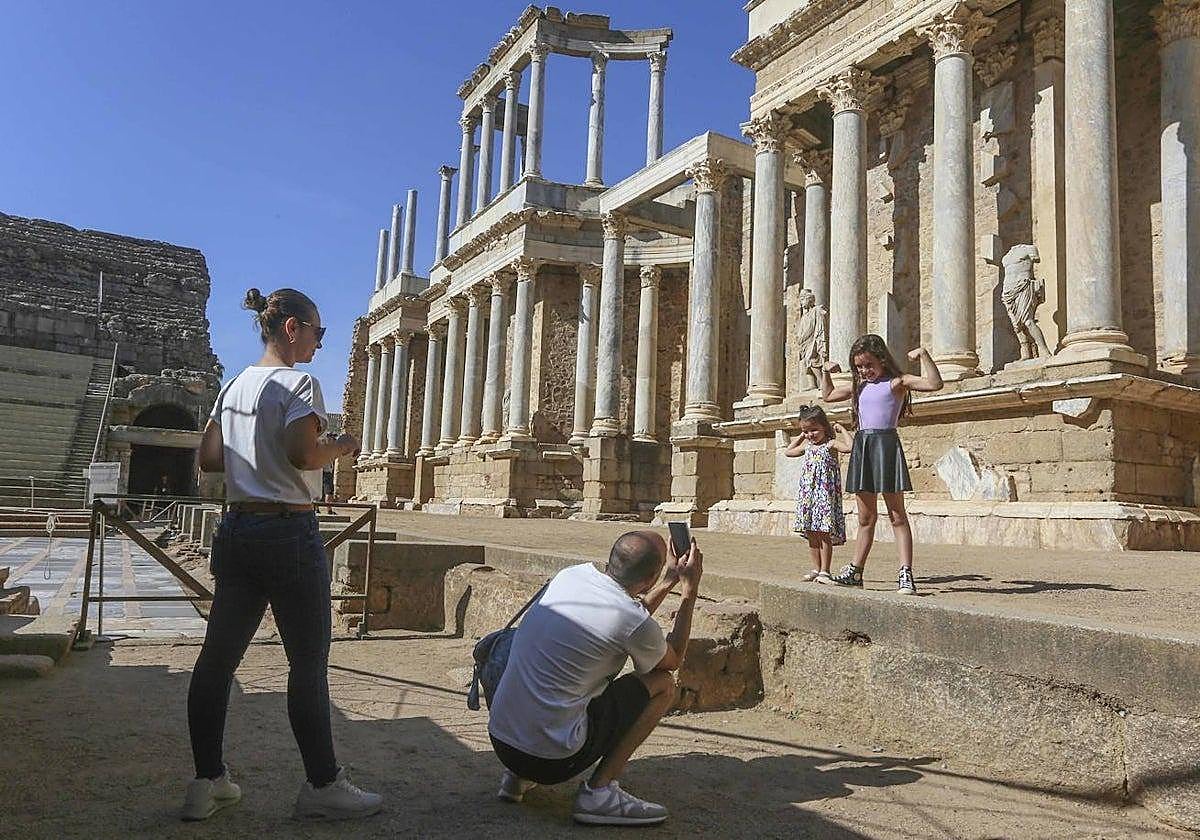 Un padre fotografía a sus hijas, durante el Punte del Pilar de 2023, en la escena del Teatro Romano de Mérida.