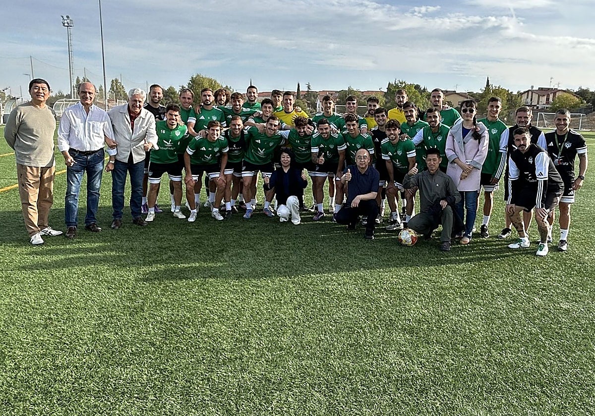 Los representantes de la Fundación Lumbini posan con los jugadores del Cacereño.