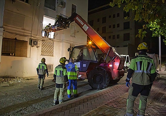 Bomberos del parque de Mérida bajan al vecino de calle Panadero por el hueco abierto por su ventana del exterior del piso para ser llevado al hospital, anoche.