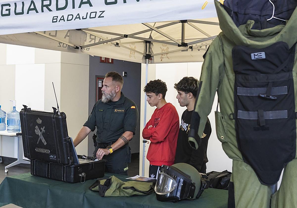 Dos jóvenes reciben explicaciones de un agente de la Guardia Civil.