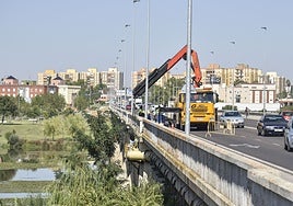 Una grúa reparando una de las averías en la tubería del puente de la Universidad.
