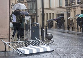 Imagen de archivo de gente paseando con paraguas por el centro de Cáceres.