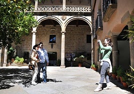 Turistas  visitan el patio del Palacio Episcopal de Plasencia.