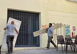 Dos operarios sacan puertas del edificio de Pintores-Moret como paso previo a la obra de reforma.