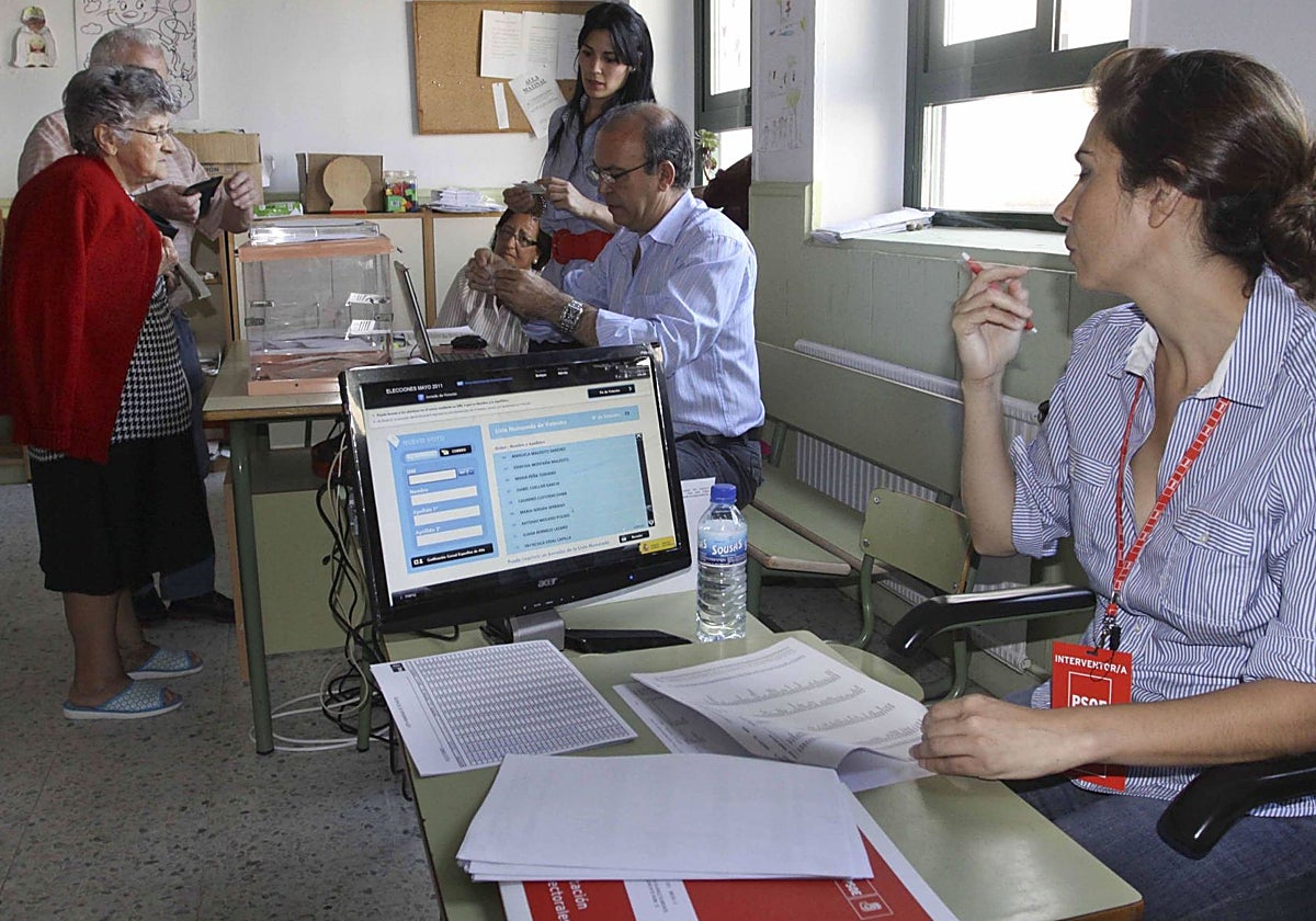 Dos personas votan en un colegio electoral en Mérida.
