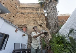 Rodrigo Albarrán, dueño de la casa que linda con la Torre de Caleros, muestra una de las piedras caídas en su patio en junio de este año.