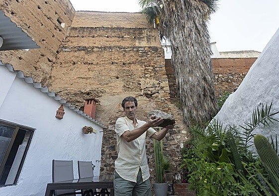 Rodrigo Albarrán, dueño de la casa que linda con la Torre de Caleros, muestra una de las piedras caídas en su patio en junio de este año.