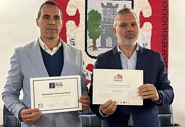 Fernando Pizarro recibe el título de manos de Pedro José Román, presidente de la Federación Extremeña.