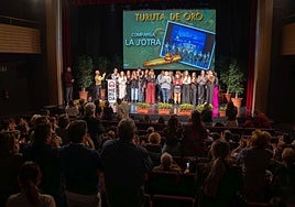 El público del teatro, en pie, aplaude a la comparsa La J'otra y sus integrantes devuelven el aplauso.