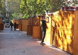 Un operario esta mañana en la instalación de uno de los puestos del mercado artesanal en el parque López de Ayala.