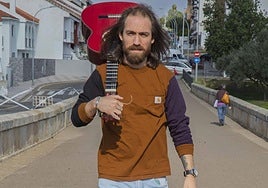 Jesús Juez, el Shuli, con su guitarra por el puente romano del Albarregas.