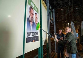Óscar Fernández pegando carteles en Cáceres en el arranque de campaña.