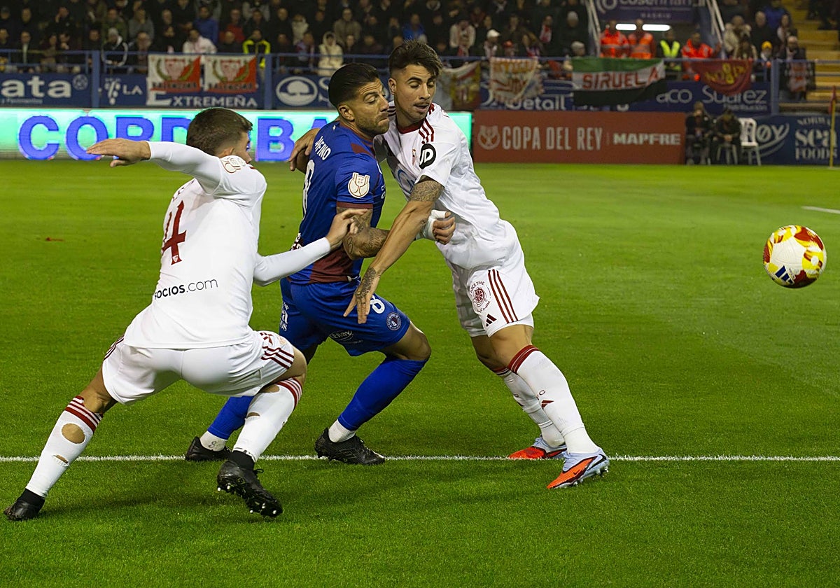 Zarfino entre dos jugadores del Sevilla en la Copa.