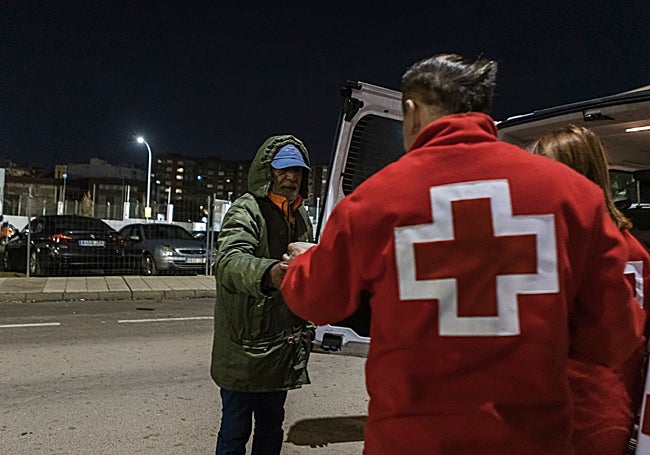 Rafael Carballo, voluntario de Cruz Roja que afirma que existe aporofobia, reparte café a un 'sintecho' este jueves.