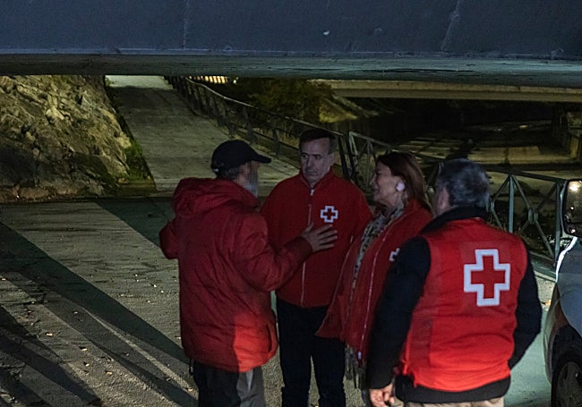 Los vuluntarios hablan con un hombre bajo un puente de Badajoz.