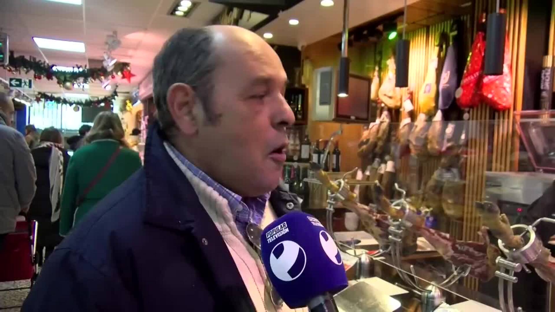 Clientes en un mercado de Murcia eligen marisco y jamón para Nochebuena