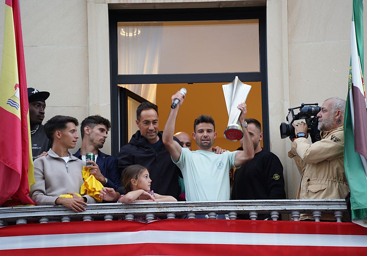 Carlos López, con el trofeo y junto a varios compañeros en el balcón del Ayuntamiento.