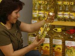 Una mujer consulta el precio de una botella de aceite de girasol. /ARCHIVO