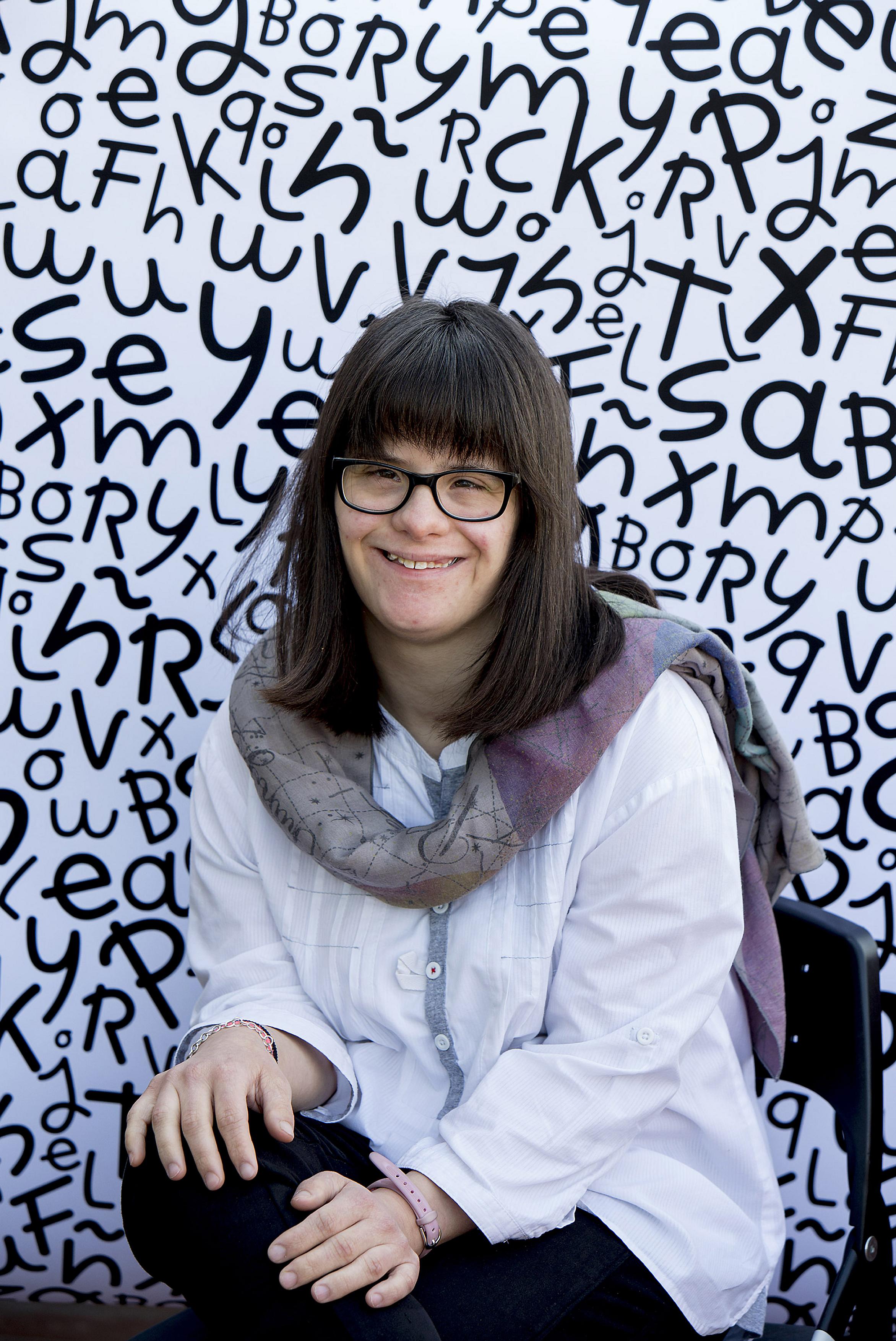 Anna Vives posa con la tipografía que ha creado de fondo.
