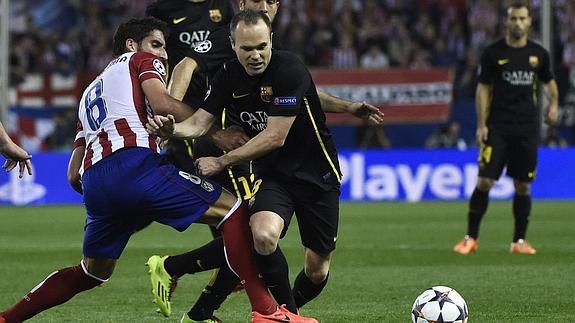 Raúl García e Iniesta pelean por un balón.