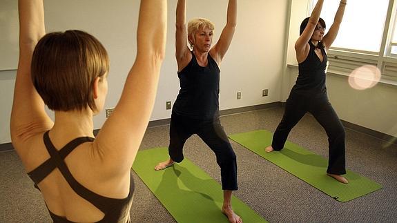 Mujeres que han superado un cáncer practican yoga. 