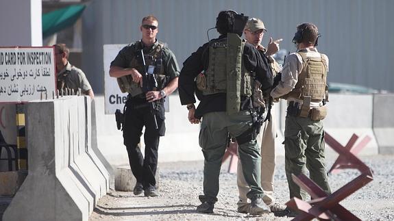 Oficiales de seguridad extranjeros inspeccionan el lugar tras el ataque suicida.