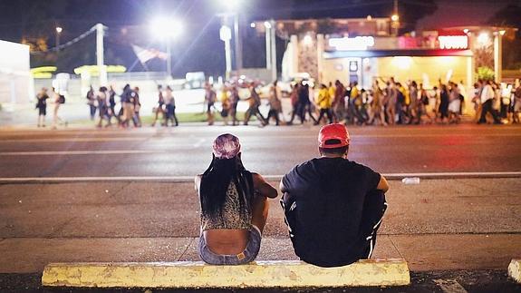 Dos jóvenes observan las manifestaciones por la muerte de Michael Brown. 