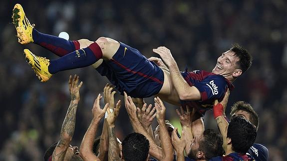 Los jugadores del Barça mantean a Messi. 