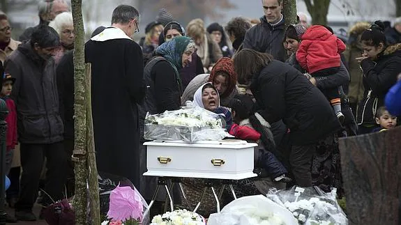La madre de la bebé llora durante su entierro.