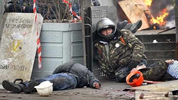 Manifestantes contra el gobierno ucraniano, junto a los cuerpos de compañeros muertos por francotiradores. 