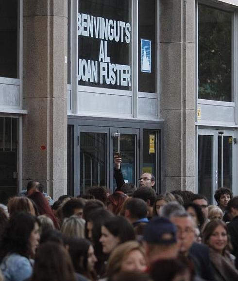 Varias personas reunidas a las puertas del Instituto Joan Fuster. 