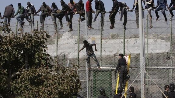 Varios inmigrantes intentan cruzar la valla de Melilla.