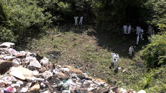 Un grupo de expertos forenses trabaja en el lugar donde presuntamente fueron incinerados los cuerpos.