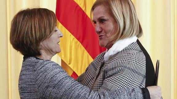 La nueva presidenta del Parlament, Carme Forcadell (i) se despide de la presidenta saliente Núria de Gispert (d) tras la sesión constitutiva del nuevo Parlament.