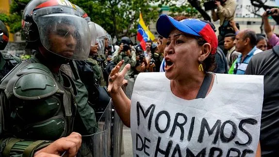 Un manifestante protesta delante de la policía venezolana.