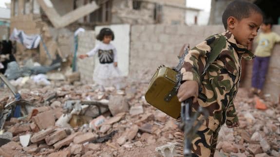 Un niño, con una metralleta de juguete, en Saná.