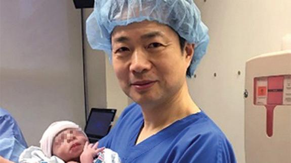 El doctor John Zhang junto al bebé.