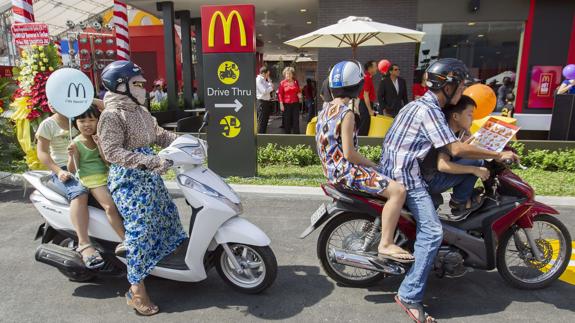 Una familia compra desde la moto en el primer McDonals de Vietnam.