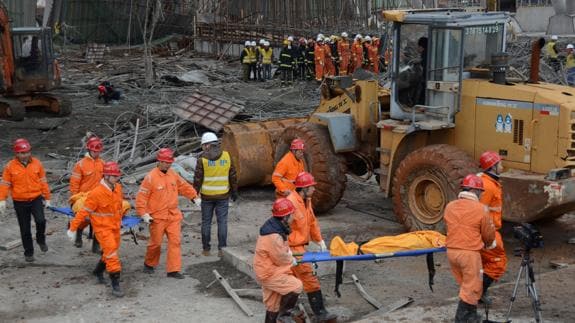 Efectivos de rescate extraen los cuerpos de los trabajadores fallecidos en el derrumbe.