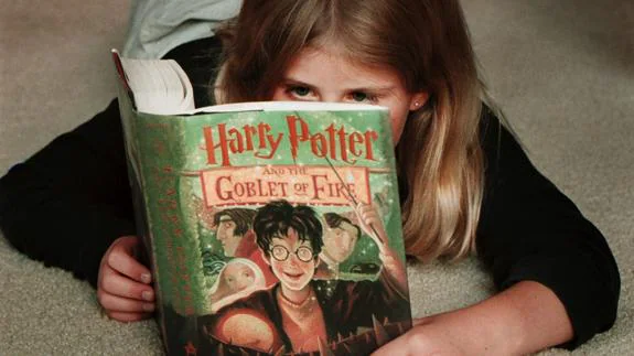 Una niña leyendo un libro sobre Harry Potter.
