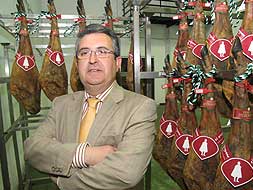 Vidal Julio Ramos rodeado de perniles en la sede de la empresa Herlusa, en Arroyo de la Luz. / LORENZO CORDERO