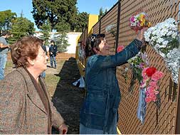 Varias personas depositan flores en el cerramiento del Jardín Botánico./ BRÍGIDO