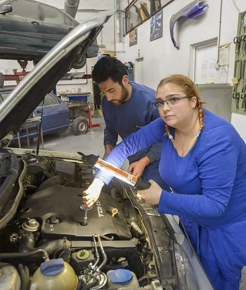 Mercedes revisa un vehículo durante las horas de clase junto a sus compañeros