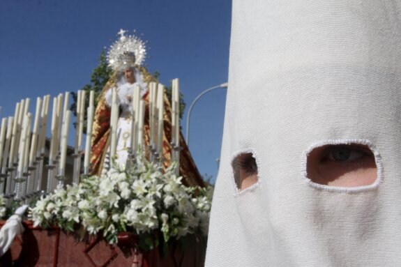 Una nazarena junto a la imagen de Nuestra Señora del Patrocinio.